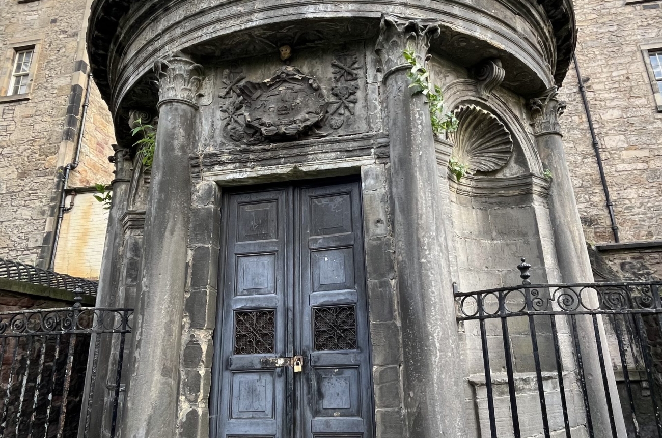 Ein Mausoleum in Edinburgh. Es ist die letzte Ruhestätte von Bloody Mackenzie, einem schottischen Rechtsgelehrten, der unfassbare Gräueltaten an seinen Landsleute verübt hat. Das Mausoleum ist von der Grundfläche rund, hat zwei hohe Türen an der Vorderseite, die mittels Schloss zugesperrt sind. Es ist aus Stein.